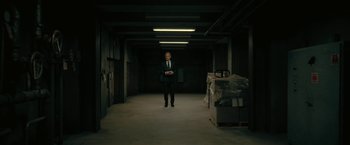 Movie still from “The Fall of the House of Usher” (2023), directed by Mike Flanagan – A man in a suit standing in an empty warehouse; Wide shot, Low angle