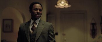 Movie still from “The Fall of the House of Usher” (2023), directed by Mike Flanagan – A man wearing a suit and tie standing in a room; Close Up shot, Low angle