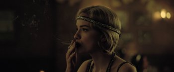 Movie still from “The Fall of the House of Usher” (2023), directed by Mike Flanagan – A beautiful young lady smoking a cigarette while wearing a headband; Close Up shot, Over the shoulder angle