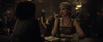 Movie still from “The Fall of the House of Usher” (2023), directed by Mike Flanagan – A woman sitting at a table smoking a cigarette in front of a man; Close Up shot, Over the shoulder angle