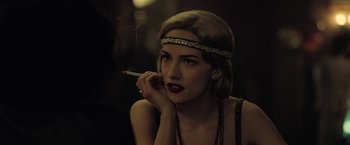 Movie still from “The Fall of the House of Usher” (2023), directed by Mike Flanagan – A woman with a cigarette in her mouth; Close Up shot, Over the shoulder angle