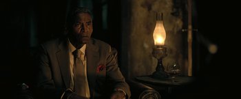 Movie still from “The Fall of the House of Usher” (2023), directed by Mike Flanagan – An older man sitting in front of an oil lamp; Close Up shot, Low angle