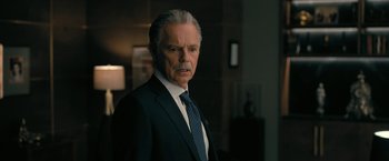 Movie still from “The Fall of the House of Usher” (2023), directed by Mike Flanagan – An older man wearing a suit and tie; Close Up shot, Over the shoulder angle