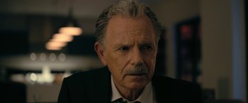 Movie still from “The Fall of the House of Usher” (2023), directed by Mike Flanagan – An older man with a mustache and a beard wearing a suit and tie; Close Up shot, Over the shoulder angle