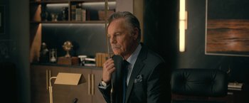 Movie still from “The Fall of the House of Usher” (2023), directed by Mike Flanagan – An older man in a suit holding a bow and arrow; Close Up shot, Low angle