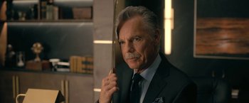 Movie still from “The Fall of the House of Usher” (2023), directed by Mike Flanagan – An older man in a suit and tie holding a sword; Close Up shot, Over the shoulder angle