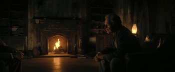 Movie still from “The Fall of the House of Usher” (2023), directed by Mike Flanagan – A man sitting in front of a fire place; Medium shot, Over the shoulder angle