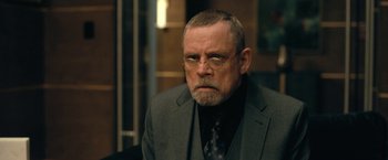 Movie still from “The Fall of the House of Usher” (2023), directed by Mike Flanagan – An older man in a suit and tie; Close Up shot, Over the shoulder angle