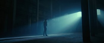 Movie still from “The Fall of the House of Usher” (2023), directed by Mike Flanagan – A man standing in the middle of an empty warehouse; Extreme Wide shot, Low angle