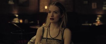 Movie still from “The Fall of the House of Usher” (2023), directed by Mike Flanagan – A beautiful blonde woman wearing a black dress; Close Up shot, Over the shoulder angle