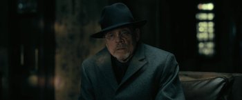 Movie still from “The Fall of the House of Usher” (2023), directed by Mike Flanagan – An older man wearing a hat and a suit; Close Up shot, Over the shoulder angle