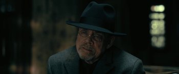 Movie still from “The Fall of the House of Usher” (2023), directed by Mike Flanagan – An older man wearing a hat and glasses; Close Up shot, Over the shoulder angle