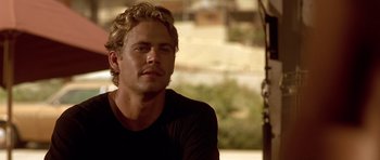 Movie still from “The Fast and the Furious” (2001), directed by Rob Cohen – A man with blonde hair is sitting down; Close Up shot, Over the shoulder angle