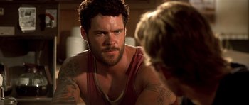 Movie still from “The Fast and the Furious” (2001), directed by Rob Cohen – A person with tattoos on their arms; Close Up shot, Over the shoulder angle