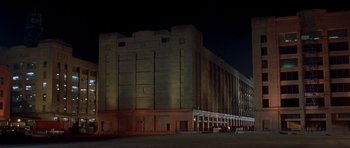 Movie still from “The Fast and the Furious” (2001), directed by Rob Cohen – A large building lit up at night with lights on it; Extreme Wide shot, Low angle