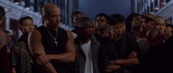 Movie still from “The Fast and the Furious” (2001), directed by Rob Cohen – A group of men standing next to each other in a row; Medium shot, Low angle