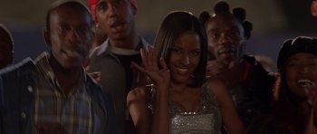 Movie still from “The Fast and the Furious” (2001), directed by Rob Cohen – A woman waving at the camera; Medium shot, Low angle