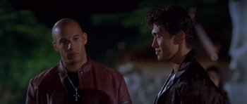 Movie still from “The Fast and the Furious” (2001), directed by Rob Cohen – Two men are standing next to each other; Close Up shot, Over the shoulder angle