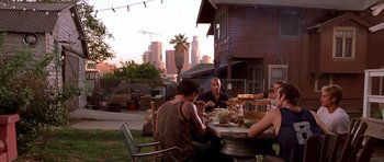 Movie still from “The Fast and the Furious” (2001), directed by Rob Cohen – A group of people sitting at a table eating food; Wide shot, Over the shoulder angle