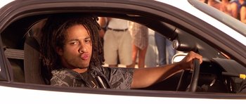 Movie still from “The Fast and the Furious” (2001), directed by Rob Cohen – A man with dreads sitting in the driver's seat of a car; Close Up shot, Low angle