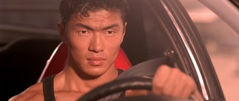 Movie still from “The Fast and the Furious” (2001), directed by Rob Cohen – A person in a car holding a steering wheel; Close Up shot, Low angle