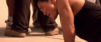 Movie still from “The Fast and the Furious” (2001), directed by Rob Cohen – A young man is doing push - ups on the ground; Close Up shot, High angle
