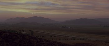 Movie still from “The Fast and the Furious” (2001), directed by Rob Cohen – A view of a valley at dusk or dawn with mountains in the background; Extreme Wide shot, High angle