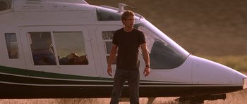 Movie still from “The Fast and the Furious” (2001), directed by Rob Cohen – A man standing in front of a white helicopter; Wide shot, Low angle