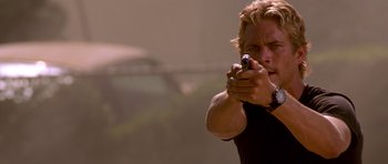 Movie still from “The Fast and the Furious” (2001), directed by Rob Cohen – A man holding a gun in his hand; Close Up shot, Low angle