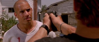 Movie still from “The Fast and the Furious” (2001), directed by Rob Cohen – A man holding a gun in front of another man's face; Close Up shot, Over the shoulder angle
