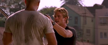Movie still from “The Fast and the Furious” (2001), directed by Rob Cohen – A man with blond hair is holding a pen in his hand; Close Up shot, Over the shoulder angle