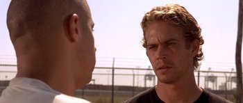 Movie still from “The Fast and the Furious” (2001), directed by Rob Cohen – Two men are facing each other in a field; Close Up shot, Over the shoulder angle