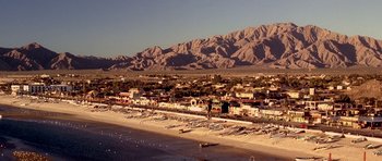Movie still from “The Fast and the Furious” (2001), directed by Rob Cohen – A view of a beach with mountains in the background; Extreme Wide shot, High angle