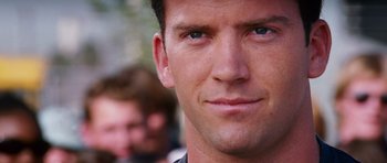 Movie still from “The Fast and the Furious: Tokyo Drift” (2006), directed by Justin Lin – A man's face with people in the background; Close Up shot, Over the shoulder angle