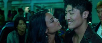Movie still from “The Fast and the Furious: Tokyo Drift” (2006), directed by Justin Lin – A man and a woman kissing in front of a crowd of onlookers; Close Up shot, Over the shoulder angle