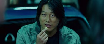 Movie still from “The Fast and the Furious: Tokyo Drift” (2006), directed by Justin Lin – A man eating a piece of food while sitting in a car; Close Up shot, Over the shoulder angle