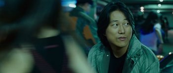 Movie still from “The Fast and the Furious: Tokyo Drift” (2006), directed by Justin Lin – A man sitting on a bus looking into the distance; Close Up shot, Over the shoulder angle