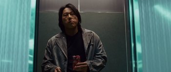 Movie still from “The Fast and the Furious: Tokyo Drift” (2006), directed by Justin Lin – A man holding a cell phone in his hand; Medium shot, Low angle