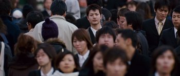 Movie still from “The Fast and the Furious: Tokyo Drift” (2006), directed by Justin Lin – A group of people standing around each other in a crowd; Medium shot, High angle