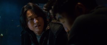 Movie still from “The Fast and the Furious: Tokyo Drift” (2006), directed by Justin Lin – Two young men are sitting in a dark room; Close Up shot, Over the shoulder angle