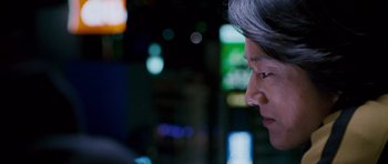 Movie still from “The Fast and the Furious: Tokyo Drift” (2006), directed by Justin Lin – A woman is looking at the lights of a building; Close Up shot, Over the shoulder angle