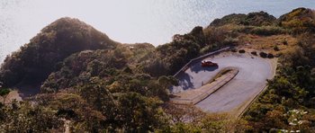 Movie still from “The Fast and the Furious: Tokyo Drift” (2006), directed by Justin Lin – An aerial view of a car driving down a road; Extreme Wide shot, High angle