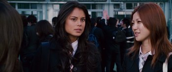 Movie still from “The Fast and the Furious: Tokyo Drift” (2006), directed by Justin Lin – A woman in a black jacket is standing in front of a group of people; Close Up shot, Over the shoulder angle