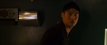 Movie still from “The Fast and the Furious: Tokyo Drift” (2006), directed by Justin Lin – A man standing in a dark room looking at the camera; Close Up shot, Low angle