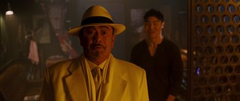 Movie still from “The Fast and the Furious: Tokyo Drift” (2006), directed by Justin Lin – A man in a suit and a hat standing next to another man in a suit; Medium shot, Over the shoulder angle