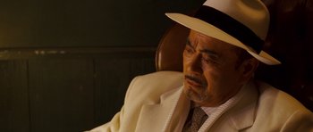 Movie still from “The Fast and the Furious: Tokyo Drift” (2006), directed by Justin Lin – An older man wearing a white suit and a white hat; Close Up shot, Over the shoulder angle