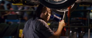 Movie still from “The Fast and the Furious: Tokyo Drift” (2006), directed by Justin Lin – A man working on a motorcycle in a garage; Medium shot, Over the shoulder angle