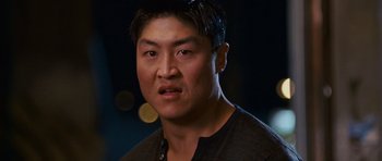 Movie still from “The Fast and the Furious: Tokyo Drift” (2006), directed by Justin Lin – A person wearing a black and brown shirt; Close Up shot, Over the shoulder angle