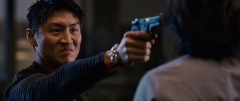 Movie still from “The Fast and the Furious: Tokyo Drift” (2006), directed by Justin Lin – A man holding a gun in his hand and aiming it; Close Up shot, Over the shoulder angle