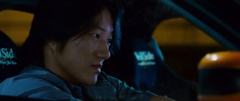 Movie still from “The Fast and the Furious: Tokyo Drift” (2006), directed by Justin Lin – A man sitting in the back seat of a car at night; Close Up shot, Low angle